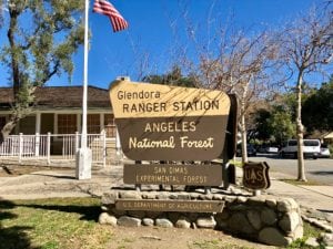 Glendora Ranger Station sign with Ranger station and American Flag in background